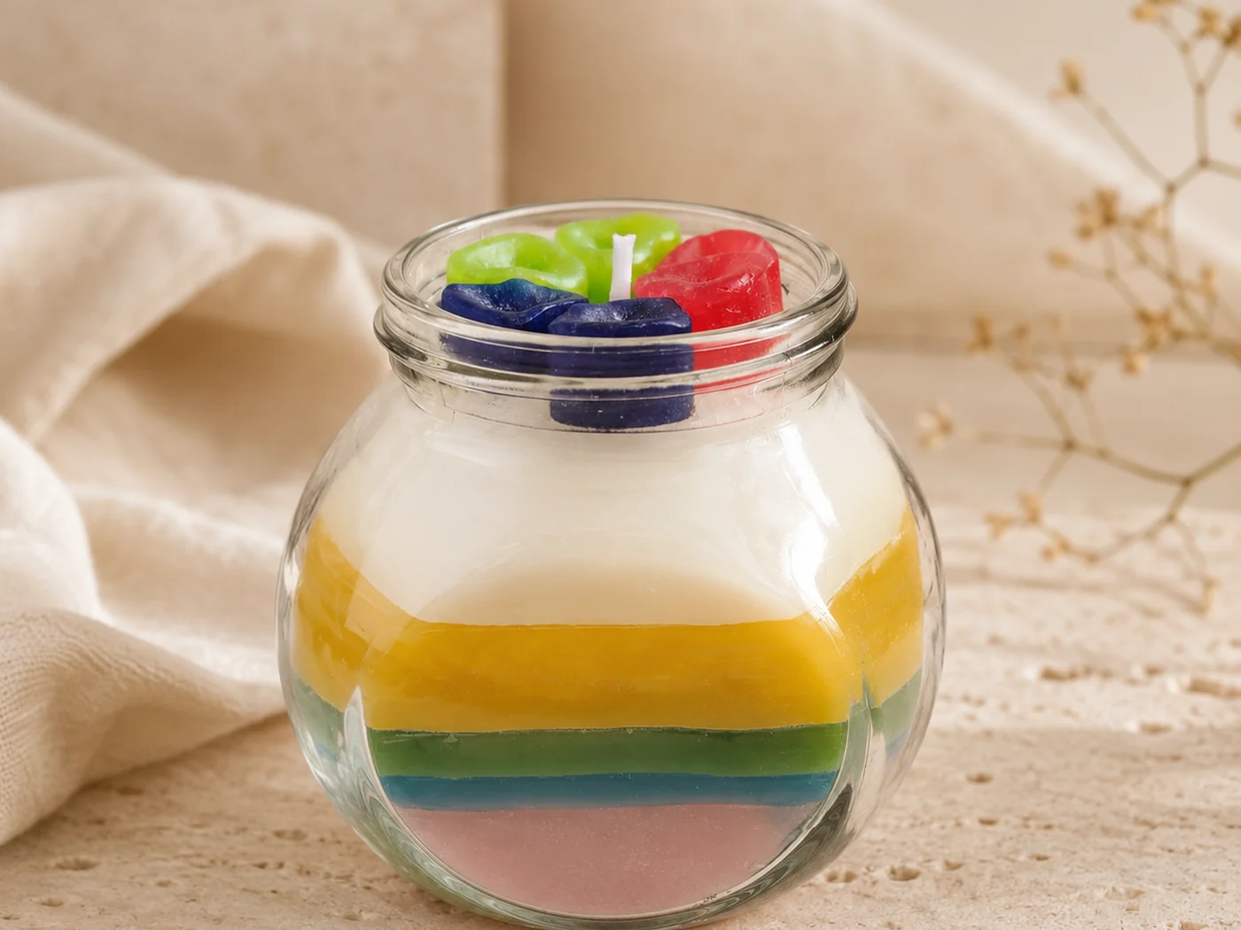 Vela artesanal en frasco de vidrio con capas de colores de Los Aromas de Rafa